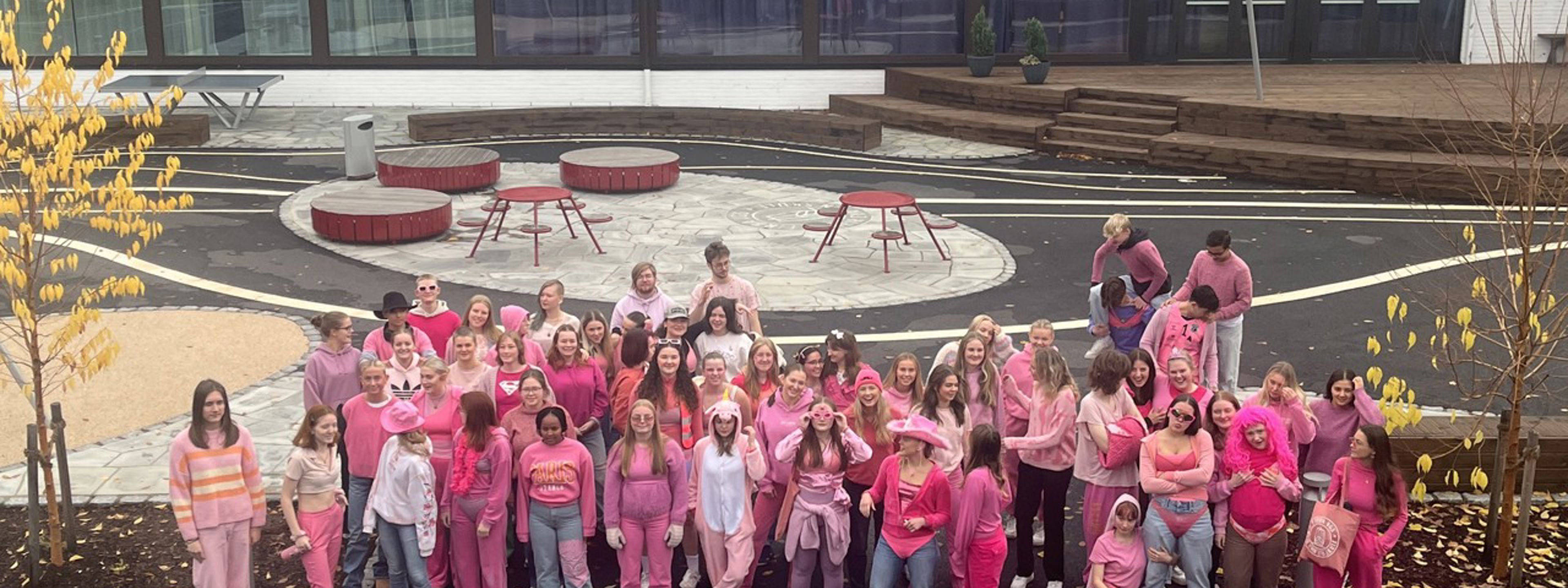 Elevar på skuleplassen i rosa kle.